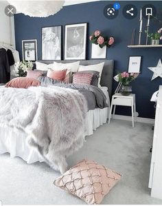 a bedroom with blue walls and white carpeted flooring is decorated in pink and grey