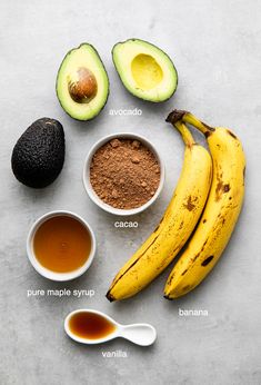 the ingredients to make an avocado smoothie laid out on a gray surface