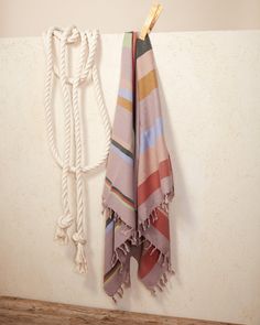 a towel hanging on a rope next to a wall with two ropes attached to it