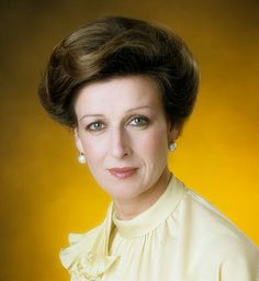 a woman in a yellow dress posing for a photo with her hair up and eyes closed