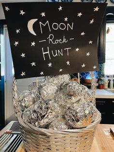 a basket filled with lots of silver foil wrapped in aluminum foil and topped with a sign that reads moon rock hunt