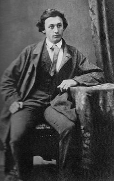 an old black and white photo of a man in a suit sitting on a chair