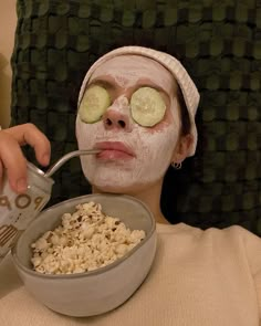 a woman with cucumber slices on her eyes and face is eating rice from a bowl