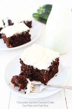 two white plates topped with brownies and frosting next to a glass of milk