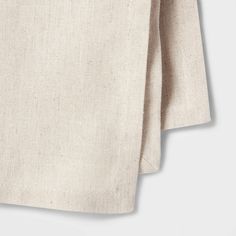 two pieces of linen are folded on top of each other, one is white and the other is beige