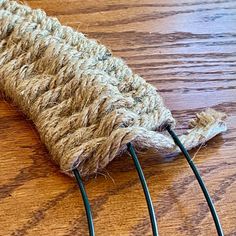 a close up of a piece of rope on a wooden table with wires attached to it