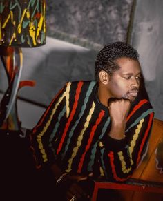 a man sitting at a table with his hand on his chin and looking off to the side