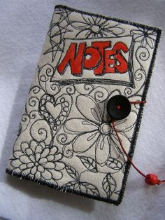 a book with the word notes written on it and a black button attached to it