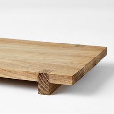 a piece of wood sitting on top of a white surface with no one around it