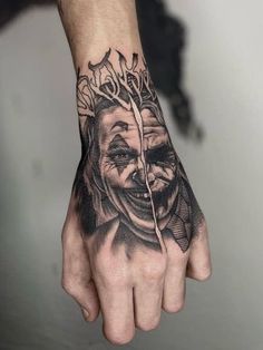 a man's hand with a tattoo on it and a drawing of a clown