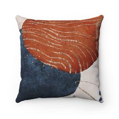 an orange, blue and white pillow with wavy lines on the front is featured against a white background