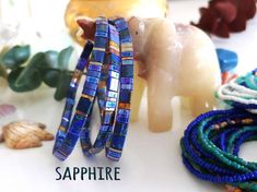 several bracelets sitting on top of a table next to shells and seashells