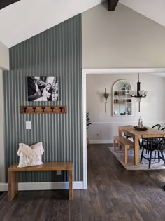 a wooden table sitting in the middle of a living room next to a wall with pictures on it