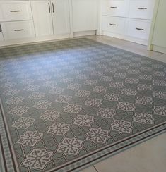 a kitchen with white cabinets and an area rug on the floor