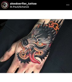 a hand with a tattoo on it and an image of a wolf's head