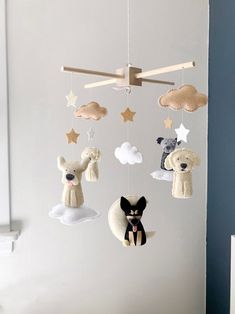 a mobile with animals and clouds hanging from it's sides on a wall in a child's room