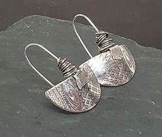 The Half Moon Pattern Earrings have a custom engraved graphic design on argentium silver. There is a 'tag' on each ear wire of fine silver. Organically wrapped argentium silver on fixed argentium silver ear wires. Each pair is handcrafted and specially unique! Silver Etched Round Earrings, Soldered Silver Teardrop Earrings, Silver Soldered Teardrop Earrings, Silver Teardrop Soldered Earrings, Silver Soldered Earrings For Anniversary, Artisan Sterling Silver Etched Earrings, Artisan Etched Sterling Silver Earrings, Engraved Sterling Silver Adjustable Earrings, Unique Silver Etched Earrings