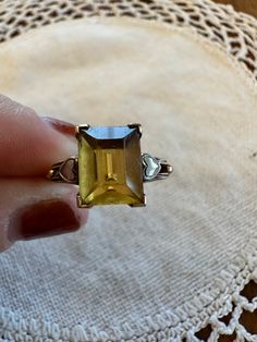 This is a beautiful vintage citrine 10 karat gold ring. It features a large rectangle citrine stone in a V-prong setting.  On each side of the stone are white gold heart accents which lead into the band.  The ring is between an 8-8.25. The band of the ring is imprinted "10K". This is a gorgeous statement ring that would be a great addition to any collector of vintage jewelry or for the someone who loves a unique jewel! Gold and stone jeweler verified.  Ring was sized by professional jeweler. Thi Yellow Citrine Topaz Ring Rectangular Shape, Vintage Amber Rectangular Jewelry, Yellow Rectangular Gemstone Rings, Yellow Citrine Rectangular Rings, Yellow Rectangular Citrine Ring, Classic Yellow Rectangular Rings, Vintage Gold Ring With Large Stone, Vintage Square Cut Gemstone Jewelry, Vintage Gold Rings With Large Stone