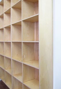 an empty bookcase in the corner of a room with carpeting on the floor