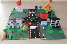 a play area with cars, buildings and flags on the ground in front of it