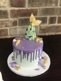 a purple and white cake sitting on top of a table