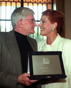 an older man and woman are smiling at each other