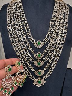 AD Diamond Finish Emerald Green Panch Five Layers Lada Long  Necklace Very pretty party wear necklace. Pair it up Sarees, Lehengas or any Party wear attire. Perfect for weddings, House warming, Half Saree Function, Baby Shower or Any Party. Necklace Length : Approx. 22 Inches; Comes with back adjustable chain. Earrings Length : 2.5 Inches; Push Back. Ready to ship from Boston, Massachusetts. Delivery time 3-5 days. If you have any questions please let me know. Thank You!! Elegant Heavy Necklaces For Party, Festive Party Necklaces With 17 Jewels, Green Stone Work Necklace For Party, Traditional Hand Set Diamond Necklace For Party, Traditional Hand-set Diamond Necklace For Parties, Heavy Silver Bridal Necklace For Party, Heavy Long Necklace For Wedding, Festival Long Necklace For Parties, Festive Party Necklace With Jewels