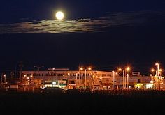 the full moon shines brightly over an industrial area