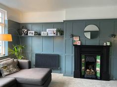 a living room filled with furniture and a fire place next to a wall mounted mirror