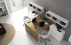 an office with a desk, chair and bookshelf in the middle of it