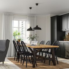 a dining room table and chairs in front of a window