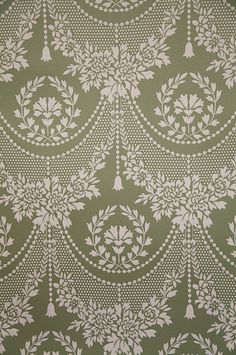 a green and white wallpaper with an intricate design on the back half of it