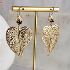 Elevate your elegance with our exquisite Heart-Shaped Filigree Earrings, a fusion of delicate artistry and captivating design. These enchanting dangle and drop earrings are meticulously crafted to showcase intricate filigree patterns that exude both grace and charm. What sets them apart is the thoughtfully designed asymmetry, where each earring is tailored to complement the side it adorns – a true embodiment of unique craftsmanship.Crowning the intricate filigree work is a shimmering stone delic Christmas Earrings Handmade, Gray Earrings, Filigree Pattern, Filigree Earrings, Filigree Design, Birthday Jewelry Gift, Gold Filigree, Earrings Drop, Opal Earrings