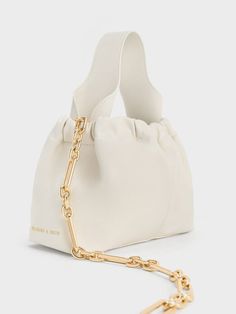 Chic Bucket Bag With Pearl Handle, Elegant Cream Pouch Bucket Bag, Cream Evening Bucket Bag Pouch, Cream Evening Bucket Bag In Pouch Shape, Evening Cream Bucket Bag, Chic Beige Bucket Bag For Day Out, Chic Beige Pouch Bucket Bag, Chic Cream Bucket Bag For Day Out, Elegant Pouch Bag For Day Out