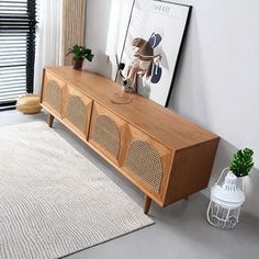 a living room with a large wooden entertainment center and white rugs on the floor