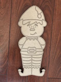 a paper cut out of a man with a helmet and boots on his head sitting on a wooden floor