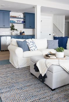 a living room with blue and white furniture in the corner, including a large sectional couch