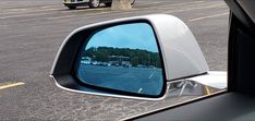 the side view mirror of a car in a parking lot