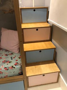 the stairs are made out of wood and have drawers on each side, along with pink pillows