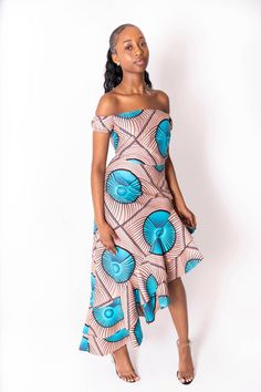 The Rela African print dress will turn heads. This gorgeous piece is stunning from top to bottom and features a laddered hem design. Made with 100% cotton fabric and stitched to exceptionally high standards, you will feel like an African Queen.  Pair this dress with some gold heels or black strappy sandals and accessorise with gold clutch and jewels.  Features: - 100% cotton  - wax print Ankara print  -zip fastening  -off shoulder design  - matching men's blazer available for couple outfits  Model 1 wears size 8 UK Mode 2 wears size 18 UK Care instructions: Hand wash or dry clean  hang to dry  do not bleach Fitted Printed Dress With Asymmetrical Hem, Summer Cotton Dress With All Over Print, Multicolor Printed Vacation Dress, Bohemian Fitted Midi Dress With High-low Hem, Printed Asymmetrical Hem Dress For Vacation, Printed Dresses With Asymmetrical Hem For Vacation, Printed Asymmetrical Hem Vacation Dresses, Cotton High-low Hem Summer Dress, Patterned Dress With All Over Print For Beach