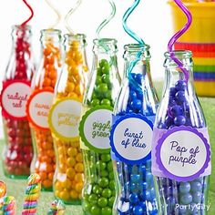 there are many different colored candies in glass bottles with tags on the top and bottom