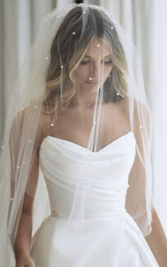 a woman wearing a white wedding dress and veil