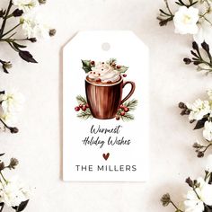 a gift tag with a hot chocolate drink on it and flowers around the label that reads, warmest holiday wishes the millers