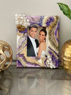 a purple and gold frame with an image of a bride and groom on the front