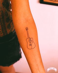 a person with a guitar tattoo on their arm