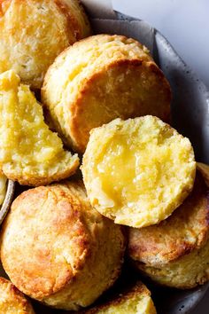 a plate full of baked biscuits with butter on the top and one bite taken out