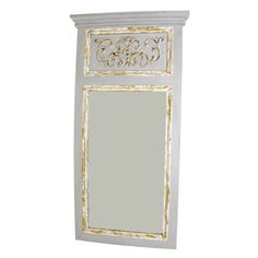 a white and gold framed mirror on a wall