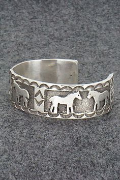 This sterling silver bracelet featuring horses was made by Navajo silversmith Preston Kinsel. The back is signed K and stamped sterling.Size: 5 5/8" (will fit up to a 6 7/8" wrist)Gap: 1 1/4"Width: 3/4"Free shipping on all orders! We ship with USPS and always include tracking. All orders ship within a day of payment.Returns are accepted up to 30 days after you receive your order. Just send us a message. Our shop offers cash back or store credit. The item must be returned in new condition. Adjustable Sterling Silver Horse Design Jewelry, Western Sterling Silver Bracelets, Western Style Sterling Silver Bracelets, Symbolic Stamped Silver Bracelets, Adjustable Sterling Silver Western Bracelet, Silver Horse Design Bracelet Jewelry, Silver Horse Design Jewelry Bracelet, Adjustable Western Sterling Silver Bracelet, Western Style Etched Sterling Silver Jewelry