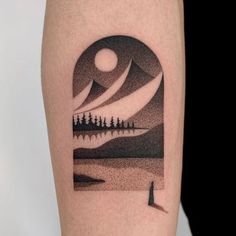 a person with a tattoo on their arm that has an image of trees and the moon