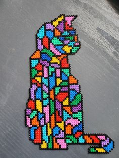 a cat made out of beads sitting on top of a table